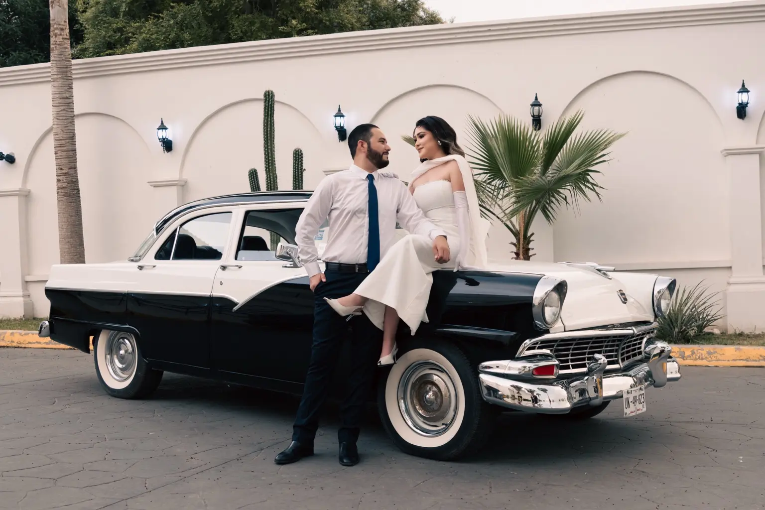 Martha Karina y Elve Jesús junto al auto clásico en el jardín